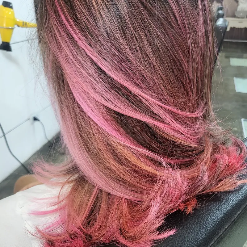 Balayage rosado sobre cabello castaño hecho en el salón